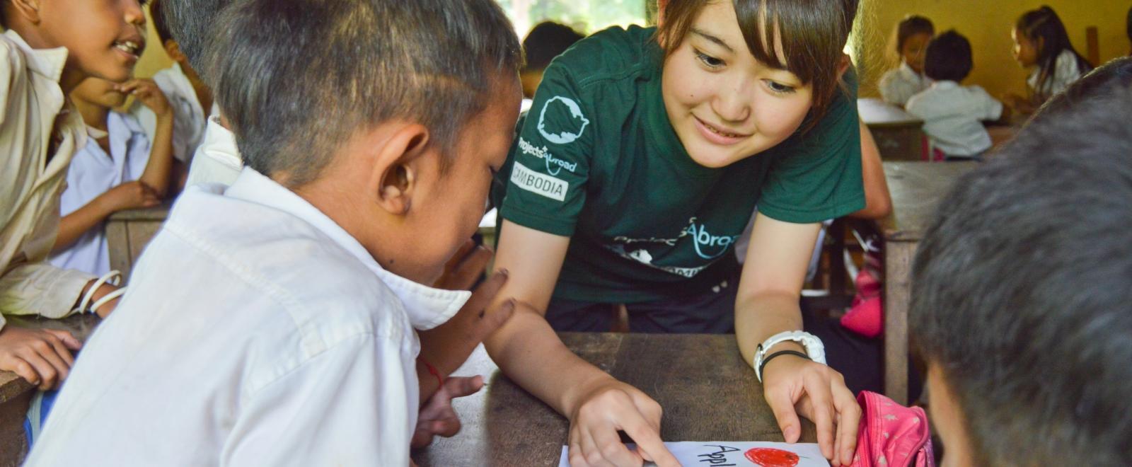 Children are taught by female volunteers working with children in Cambodia inside a community care centre to further their childhood development.