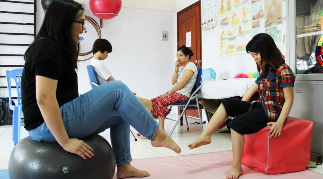 A child does physical exercises with a student doing an Occupational Therapy internship abroad for undergrads in Vietnam.