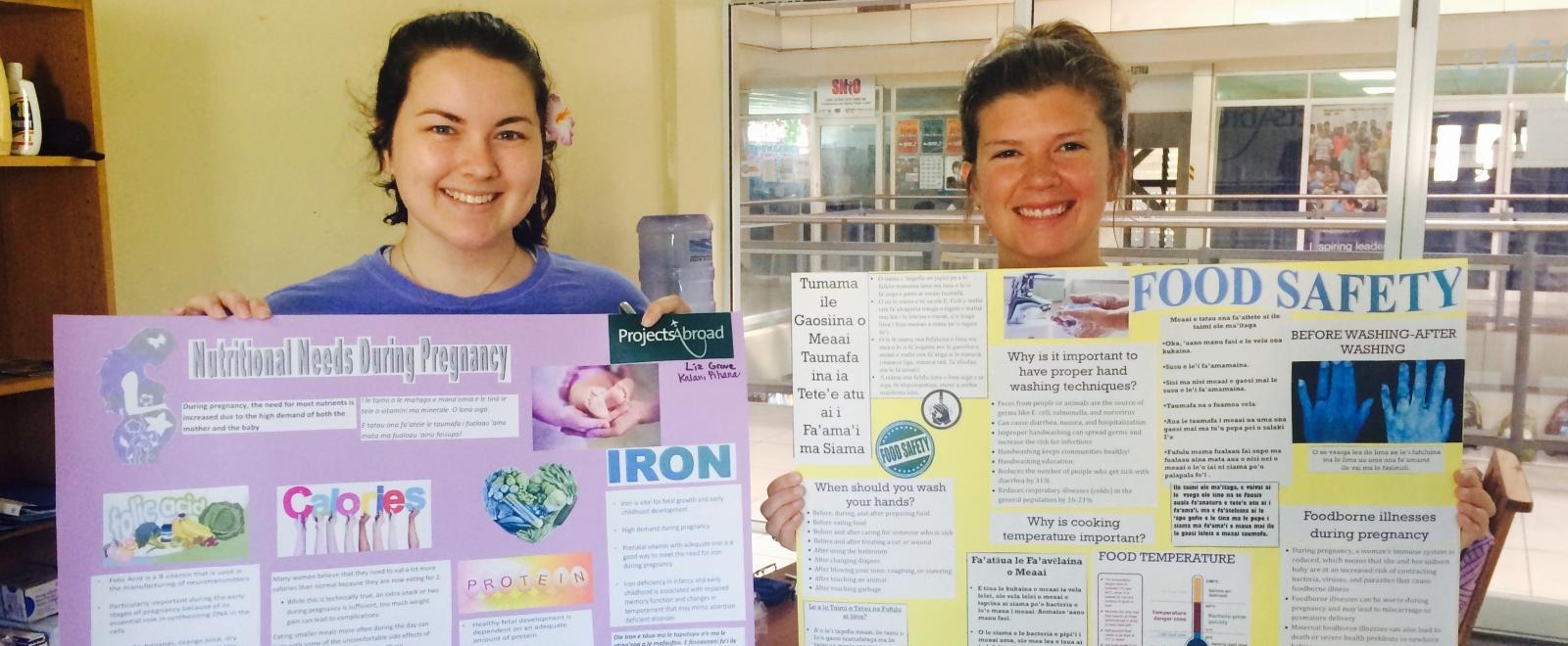 A pair of students doing Nutrition internships abroad with materials they prepared for an education and awareness campaign in local communiities.