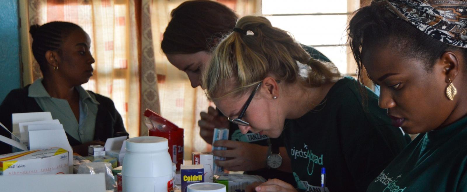 Pharmacy interns in Tanzania sort and label medication needed for a medical outreach.
