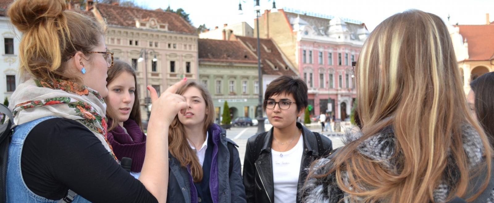 Volunteers in Romania listen to a Projects Abroad staff member during an induction tour.