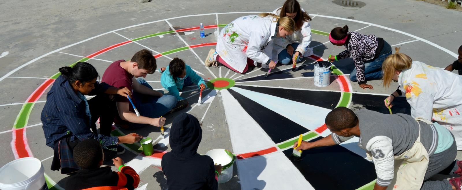 A Roundsquare group hosted by Tore’s Foundation paints a playground with local community members in Cape Town, South Africa.