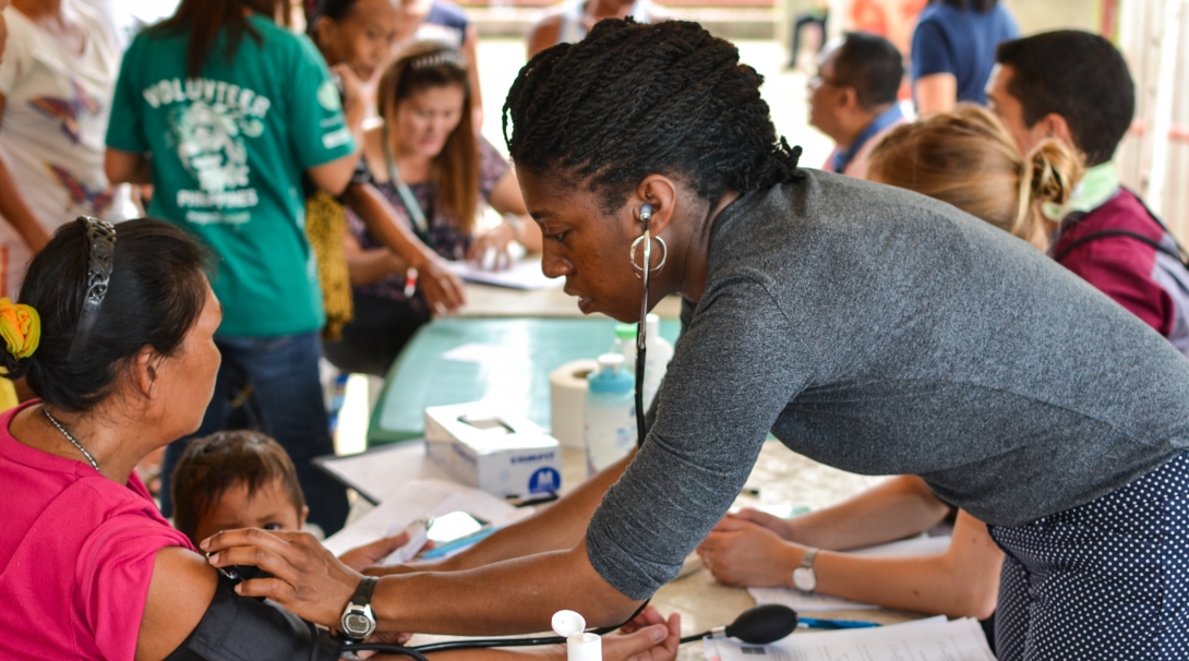 A medical volunteer takes measures during a healthcare outreach using her skills gained from volunteering abroad.