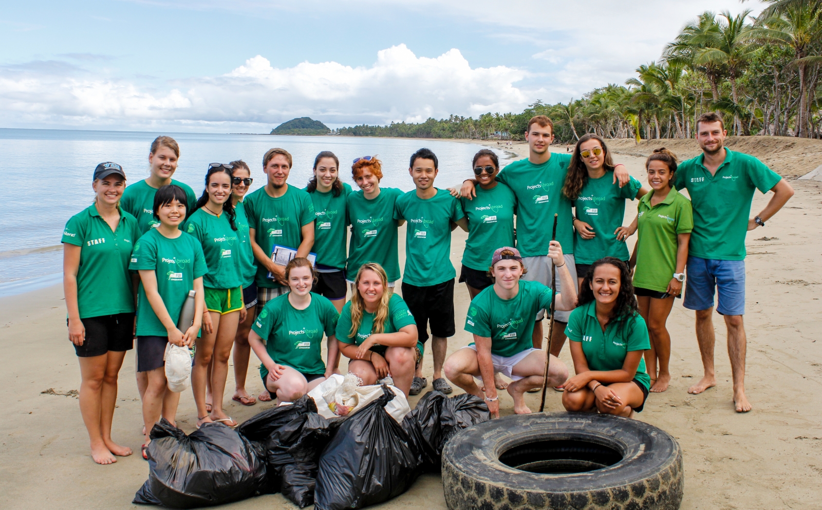 A group of Projects Abroad volunteers assist with a beach clean-up initiative where no experience is needed to volunteer overseas.