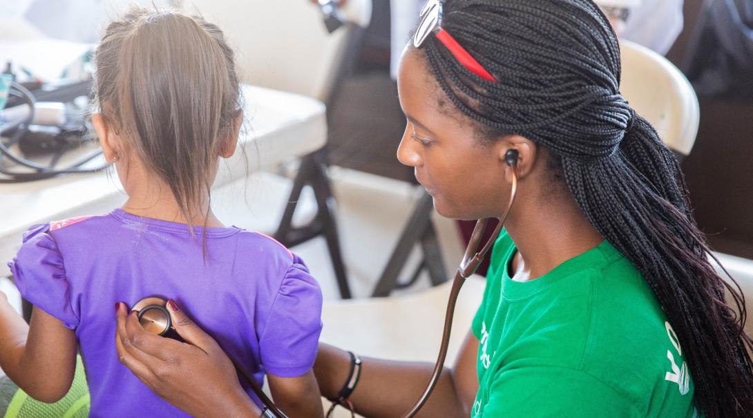 A Medicine volunteer checks a child’s heart rate on one of our best volunteer abroad programs.