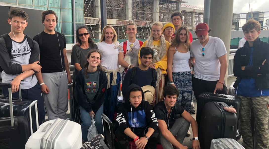 A group of 16 year olds at the airport preparing to head home after volunteering abroad.
