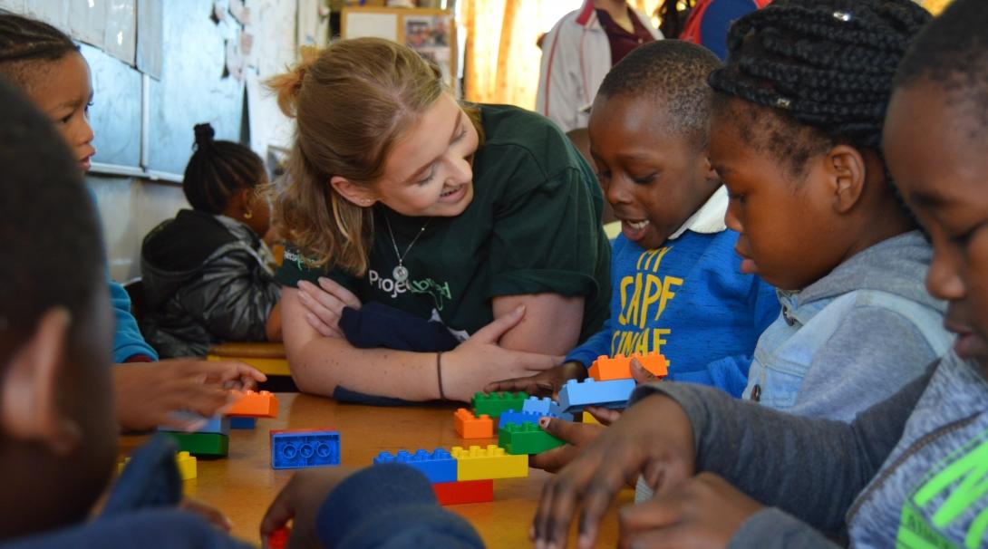 A volunteer and a group of South African children play a game on a Childcare Project in Africa