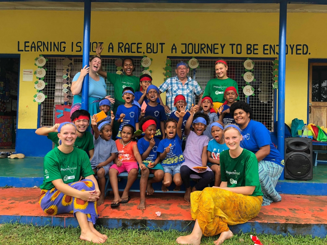 High school volunteers and children before a sports day in Fiji during their teen volunteer abroad program.