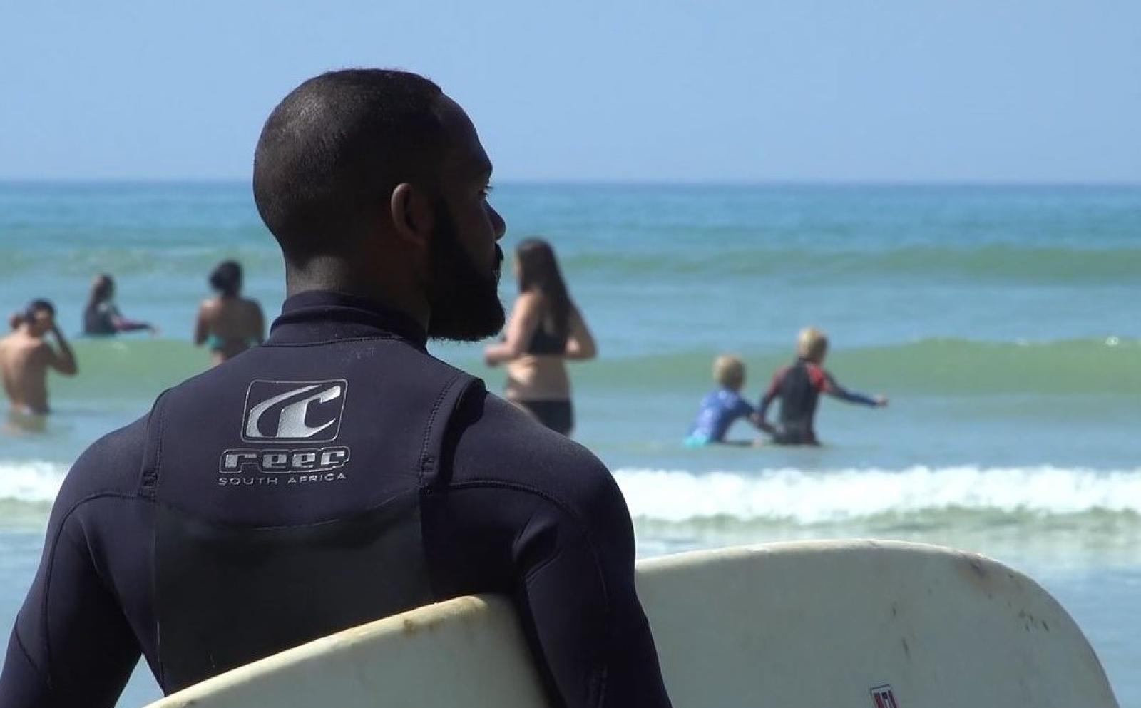 Shuan watching over the kids as they practice their surfing skills on Muizenberg beach