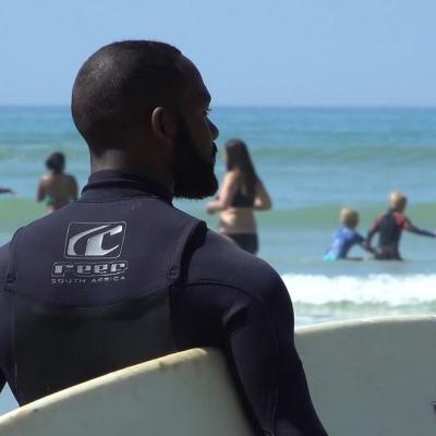 Shuan watching over the kids as they practice their surfing skills on Muizenberg beach