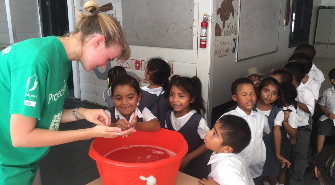 A volunteer teaches her students the most effective way to wash their hands in Belize