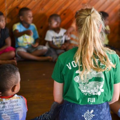 Childcare volunteer sits with her class in Fiji during her volunteer project abroad
