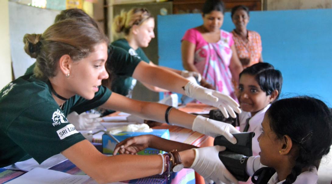 Projects Abroad volunteers measure the blood pressure of children in Sri Lanka
