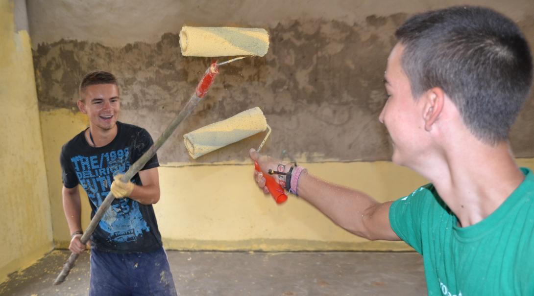 Construction volunteers in Ghana adding the finishing touches with paint.