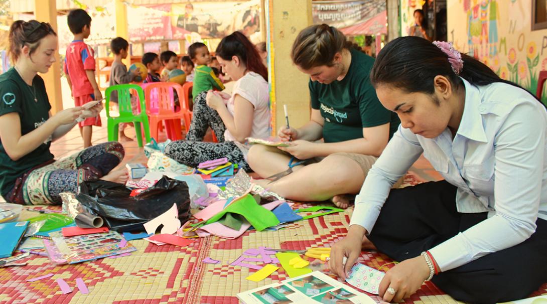 Volunteers working with children in Cambodia create educational resources to help the placement staff.