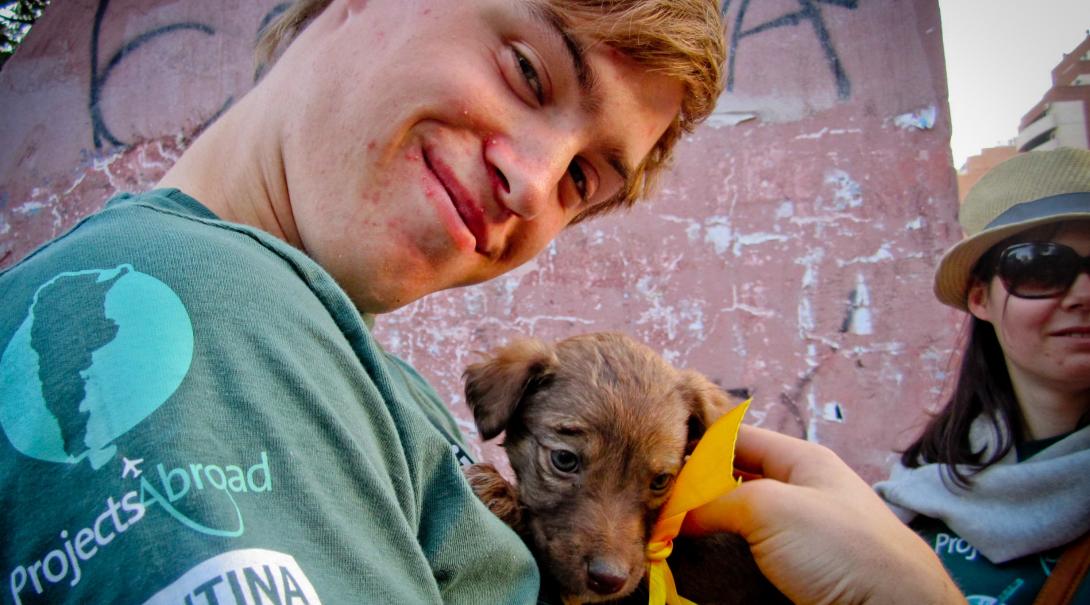 Animal care volunteer in Argentina takes a puppy to a community day to help find a new home for it.