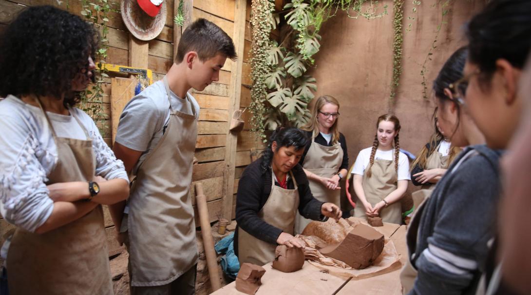 Volunteers learn about clay during a workshop as part of their community volunteer work in Peru for teenagers.