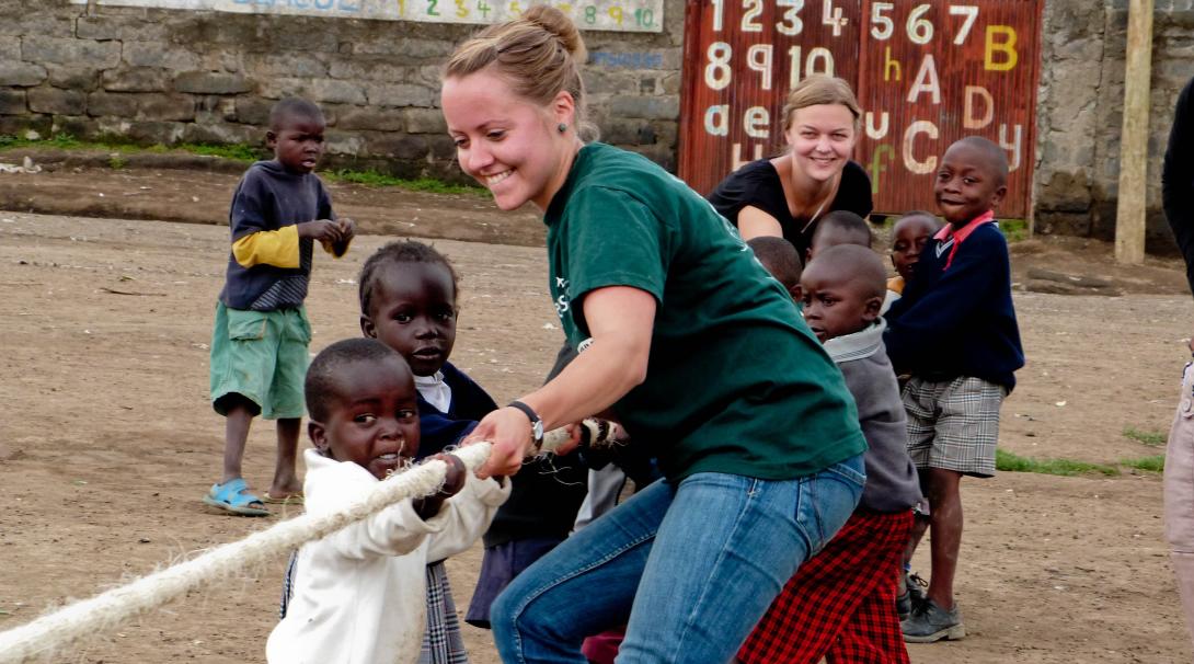 Volunteers working with children in Ghana teaches them teamwork with a fun activity.