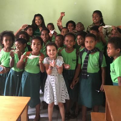 A mother and her daughter take a group photo with the students they worked with in Fiji