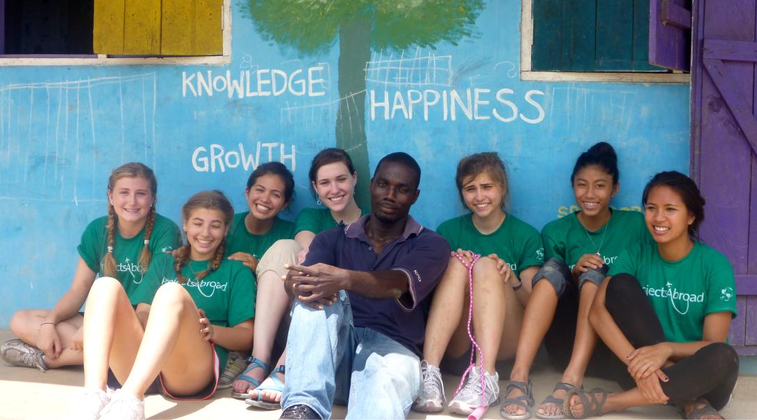 Projects Abroad volunteers sit down for a team photo before continuing their volunteer work with children in Ghana