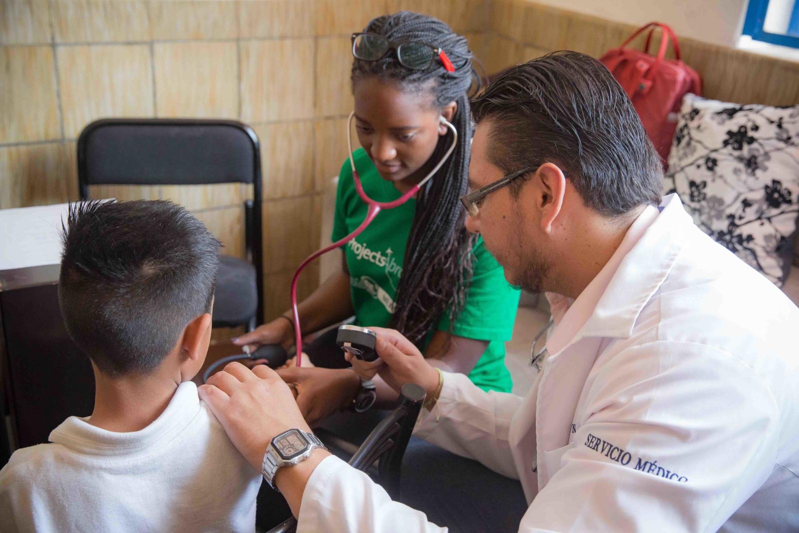Medical interns in Mexico help at an outreach alongside a local doctor. 