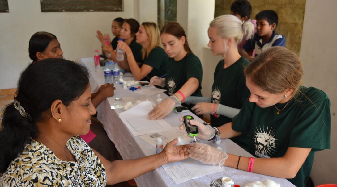 Projects Abroad volunteers test the blood sugar of locals in Sri Lanka
