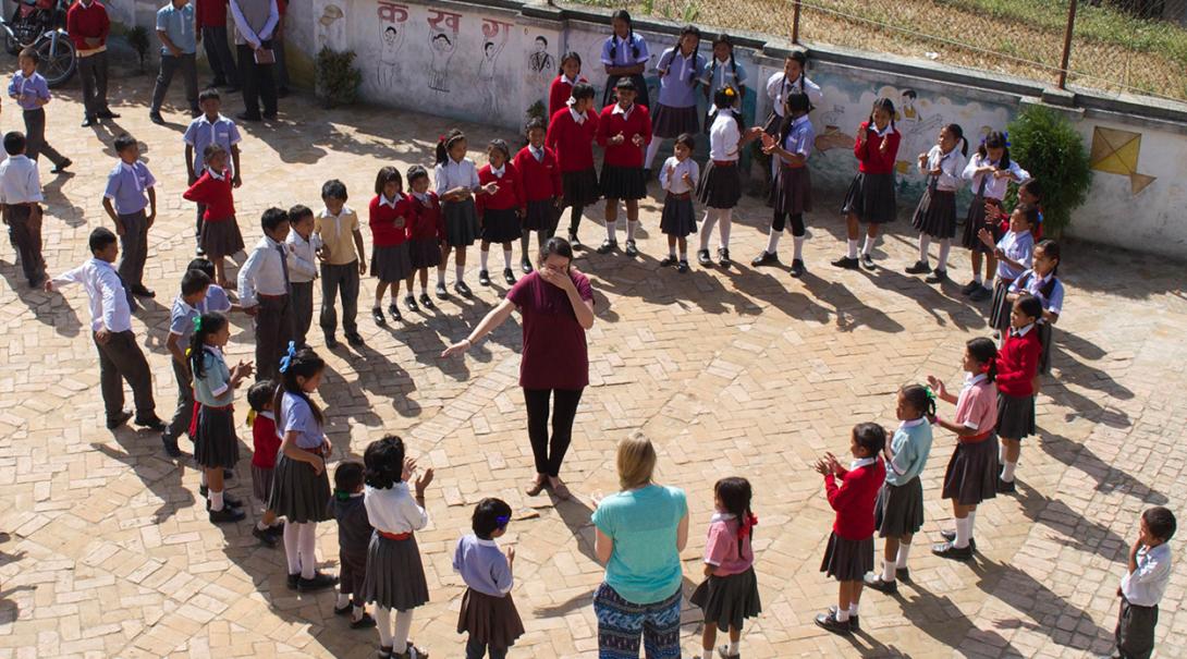Youth development volunteer playing a game with the students in Nepal