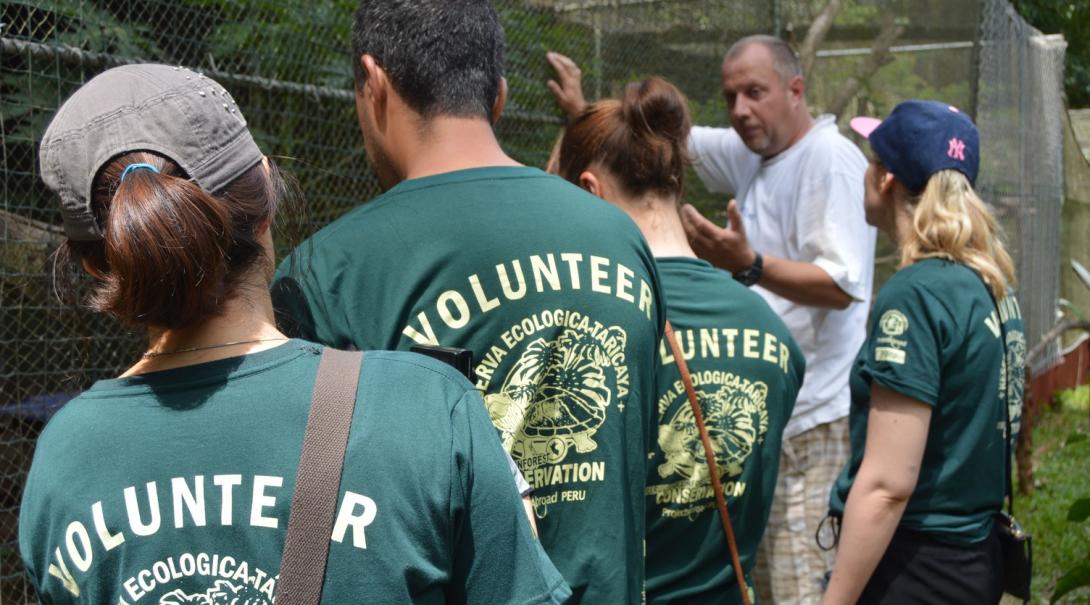 Amazon Rainforest Conservation interns listen to a staff member as he takes them through the various wildlife in the rehabilitation centre in Peru.