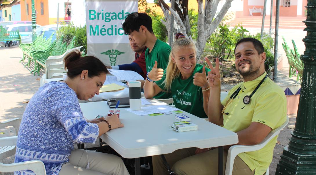 A group of high school students and a local doctor work together at a community healthcare outreach in Mexico. 