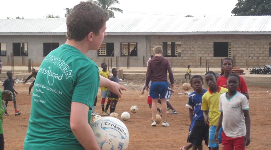 A Projects Abroad high school volunteer leads a training session to young players in Ghana. 