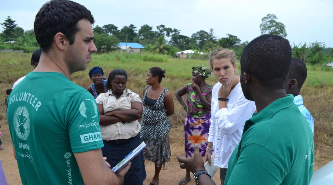 A couple of Projects Abroad volunteers discuss some solutions to a local problem with staff and local women in Ghana during their social work internship.