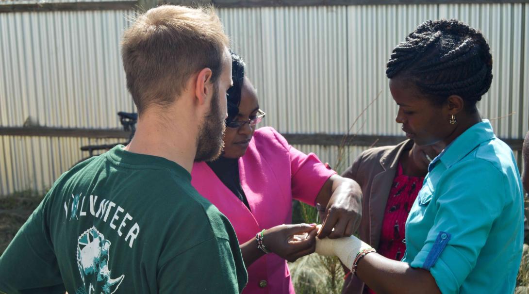 A Projects Abroad medical volunteer learns the correct way to put a bandage from a local doctor in Kenya.