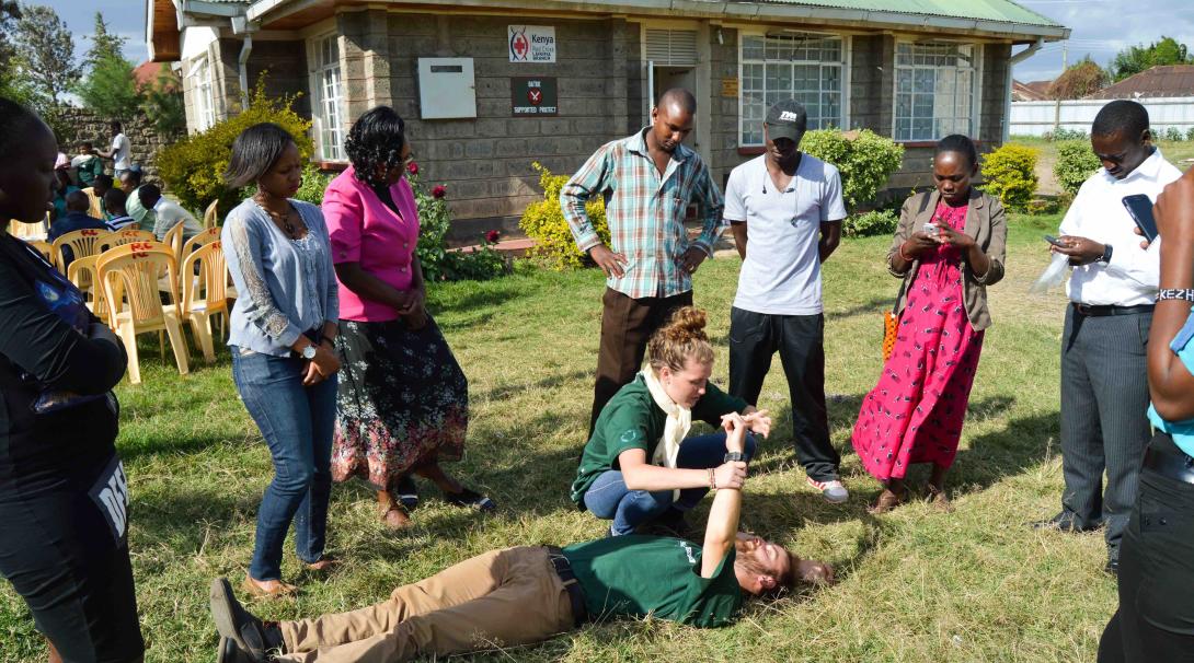 A couple of Projects Abroad medical volunteers teach some first aid techniques to local people in Kenya during a medical outreach.