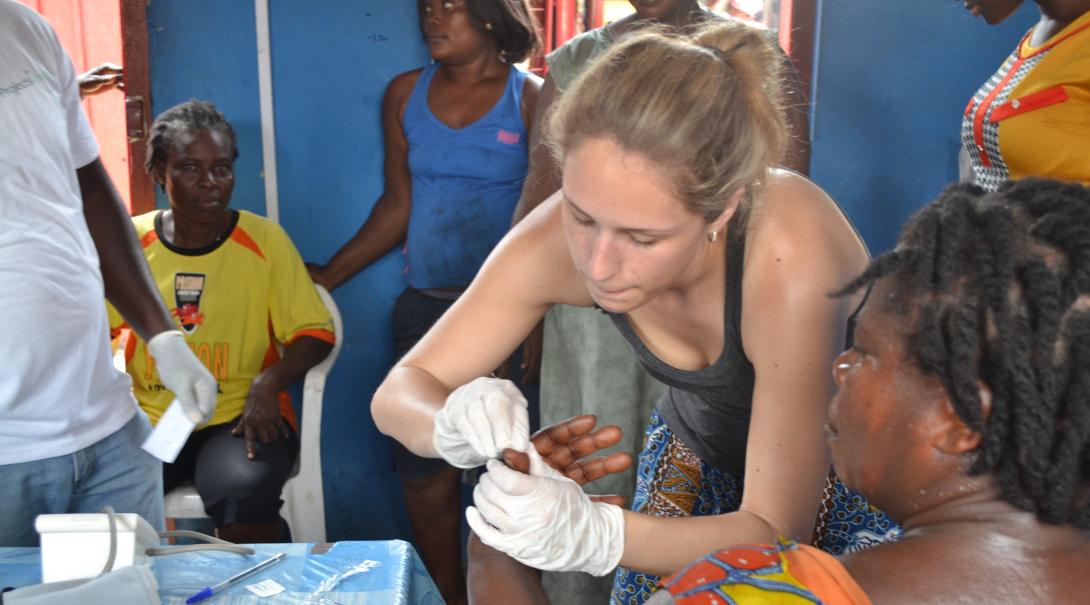 A volunteer takes a blood sample in Ghana to a pregnant woman during her midwifery internship with Projects Abroad.