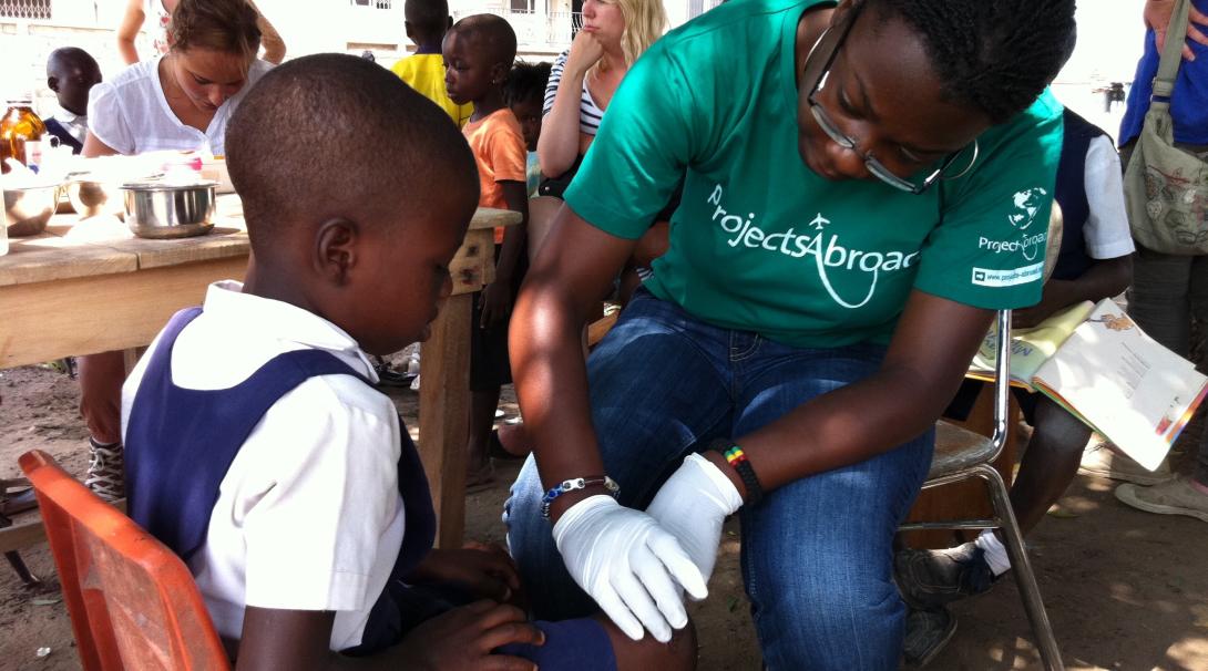 A Projects Abroad volunteer checks the leg of a young girl in Ghana as part of her physiotherapy internship.