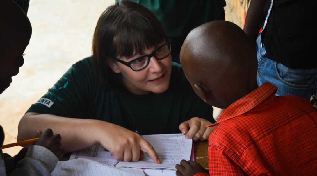 A Projects Abroad teaching volunteer helps children in Kenya with their school lesson.