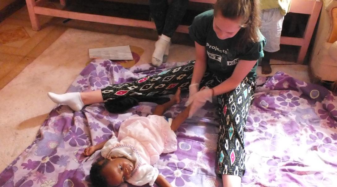 A Projects Abroad volunteer doing an Occupational Therapy internship in Kenya works on a baby's routine.
