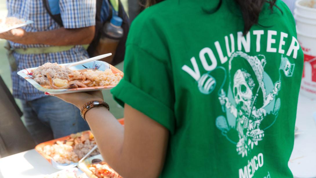Projects Abroad volunteer serves food to refugees and migrants at a shelter in Mexico.
