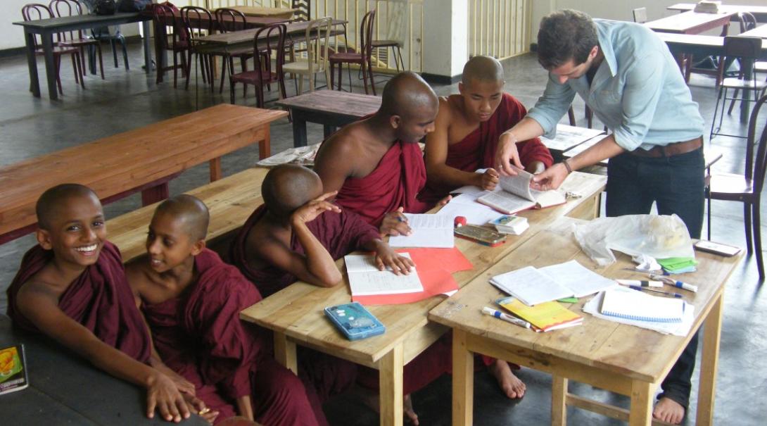 A volunteer teaches monks