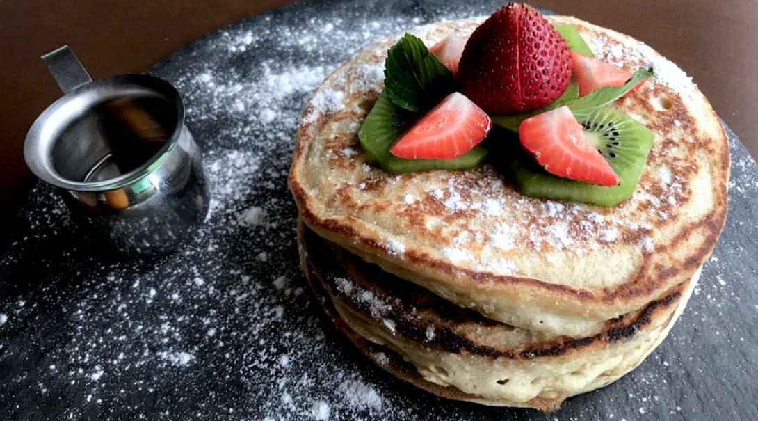 Vegan pancakes with some kiwi and strawberries on them to make the perfect vegan meal