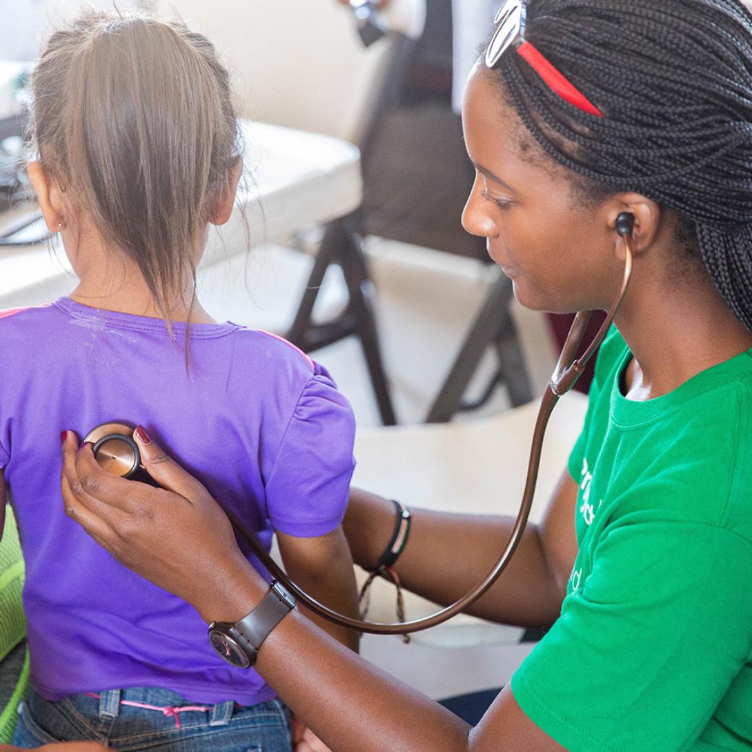 Medical intern measures the heart rate of a young girl in Mexico.
