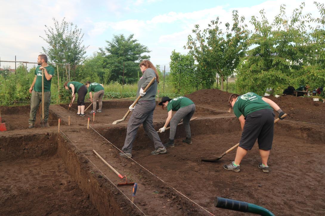 Archaeology volunteers in Romania digging at an excavation site