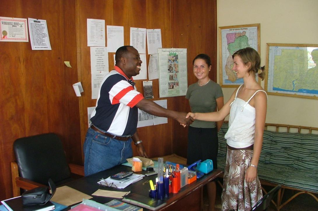 Young female volunteers shaking hands with Tom Davis in the office