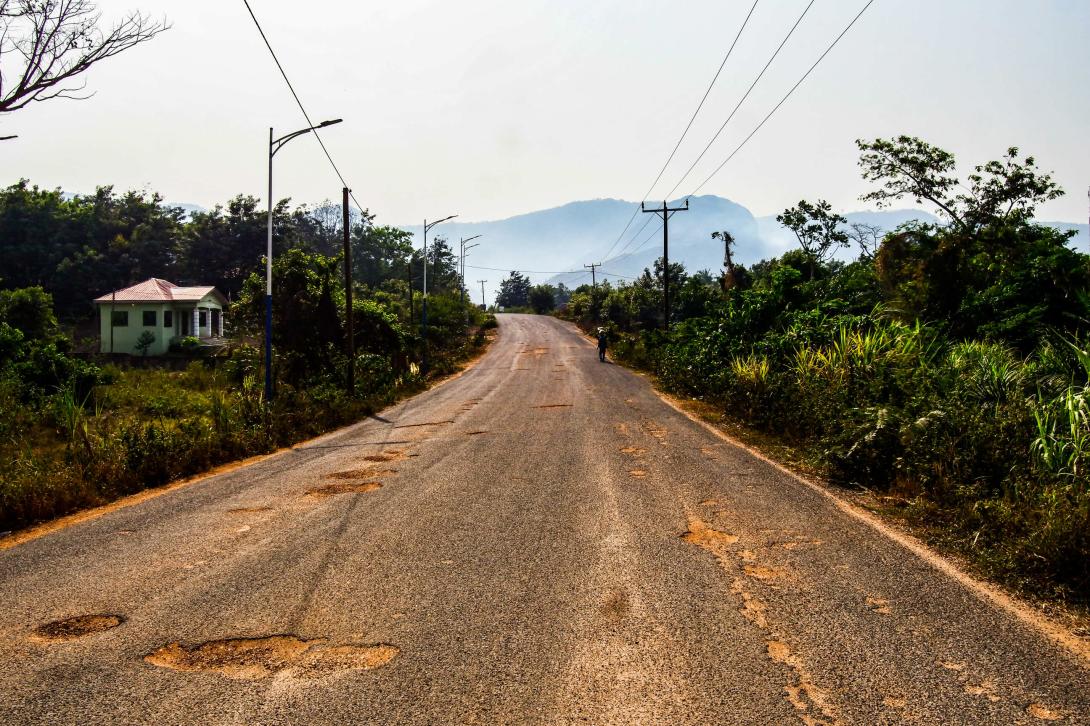 Uneven road in Wli Ghana with a mountain view